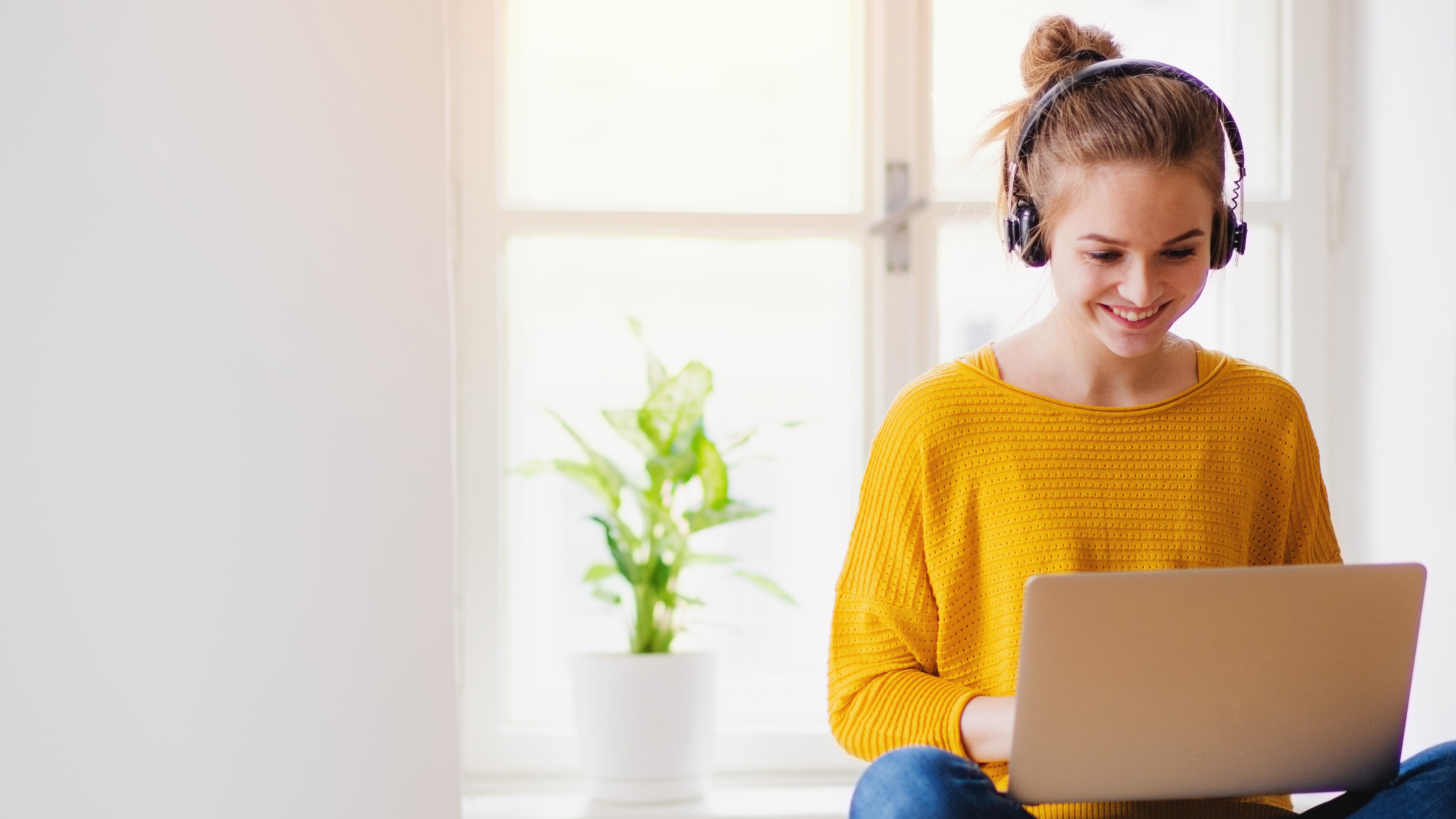 student happily working on laptop in a peaceful setting